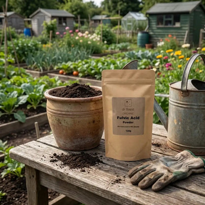 Fulvic Acid Powder — kraft pouch on allotment bench with terracotta pot of compost, gloves and watering can